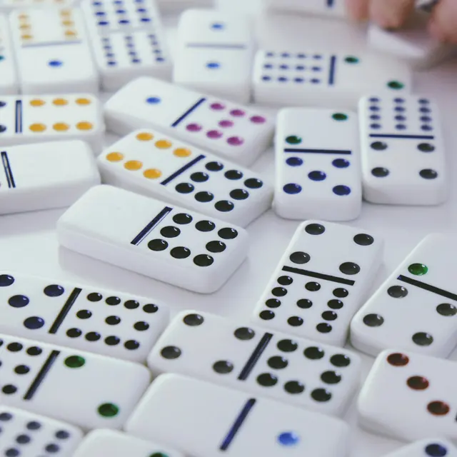 Dominos blancs à points de couleur étalés sur une table