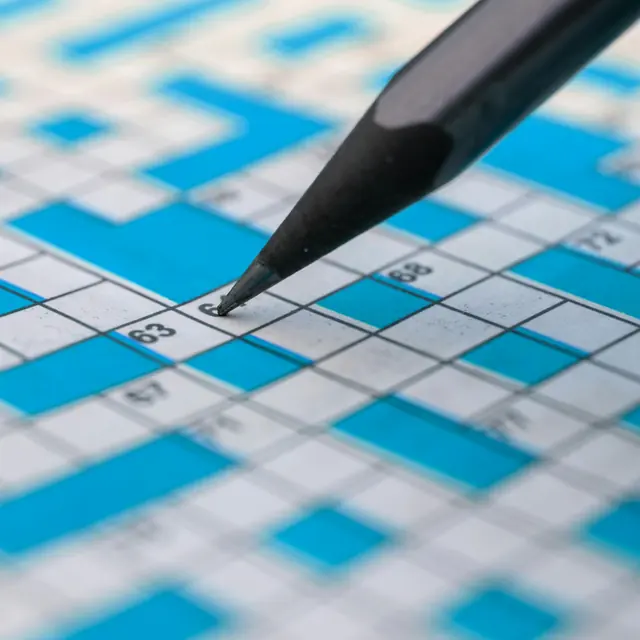 Crayon qui remplit une grille de mots croisés