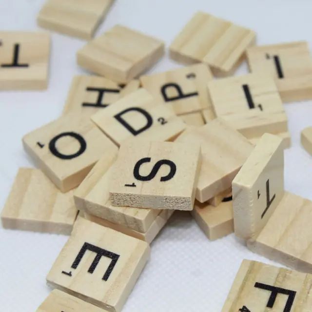 Lettres en bois éparpillées sur une surface blanche